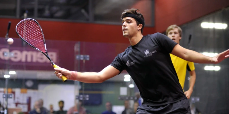 A player about to volley the ball in a squash match.